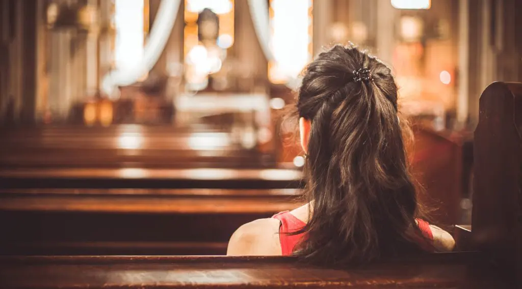 A member of an Episcopal church sits in a pew.