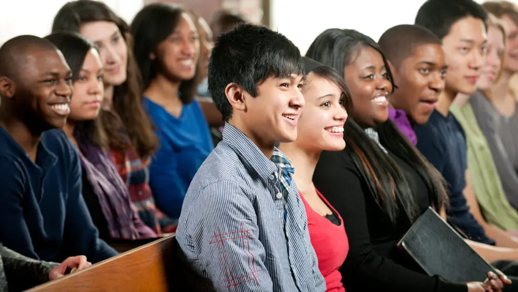 A group of parish volunteers smiles in the pews.