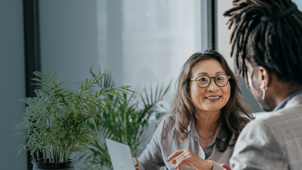 A fundraiser speaks with a donor of color in a nonprofit's office.