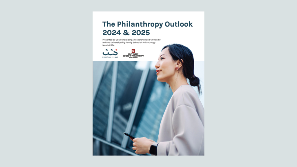 The cover page of The Philanthropy Outlook 2024 & 2025, which includes an image of person looking confidently ahead in an urban landscape.