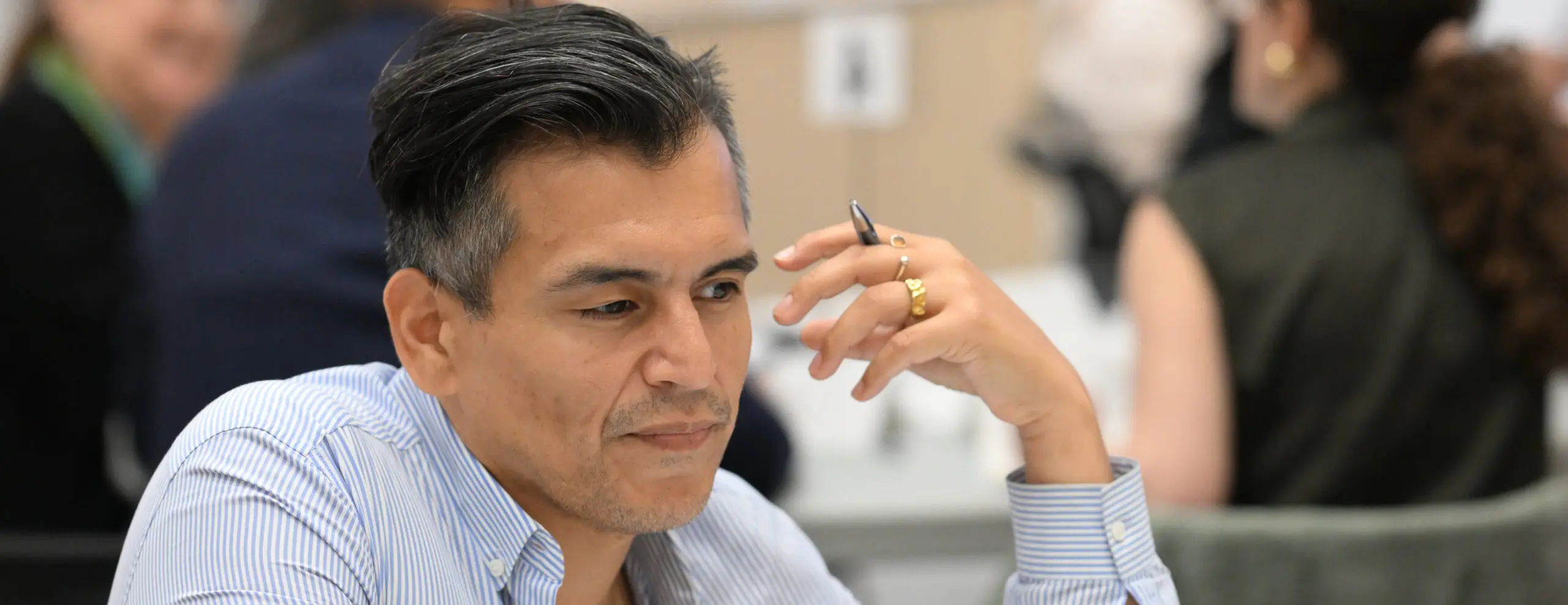 A picture of an CCS expert fundraising consultant holding a pen as they sit and brainstorm information to share in an article or publication.