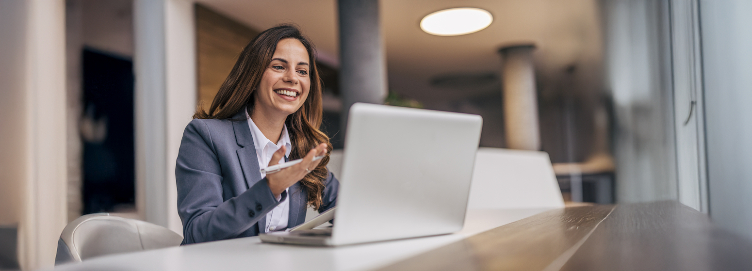 A picture of a nonprofit professional watching the Perspectives on Philanthropy | Giving USA 2025 webinar on their laptop while holding a pen in one hand.