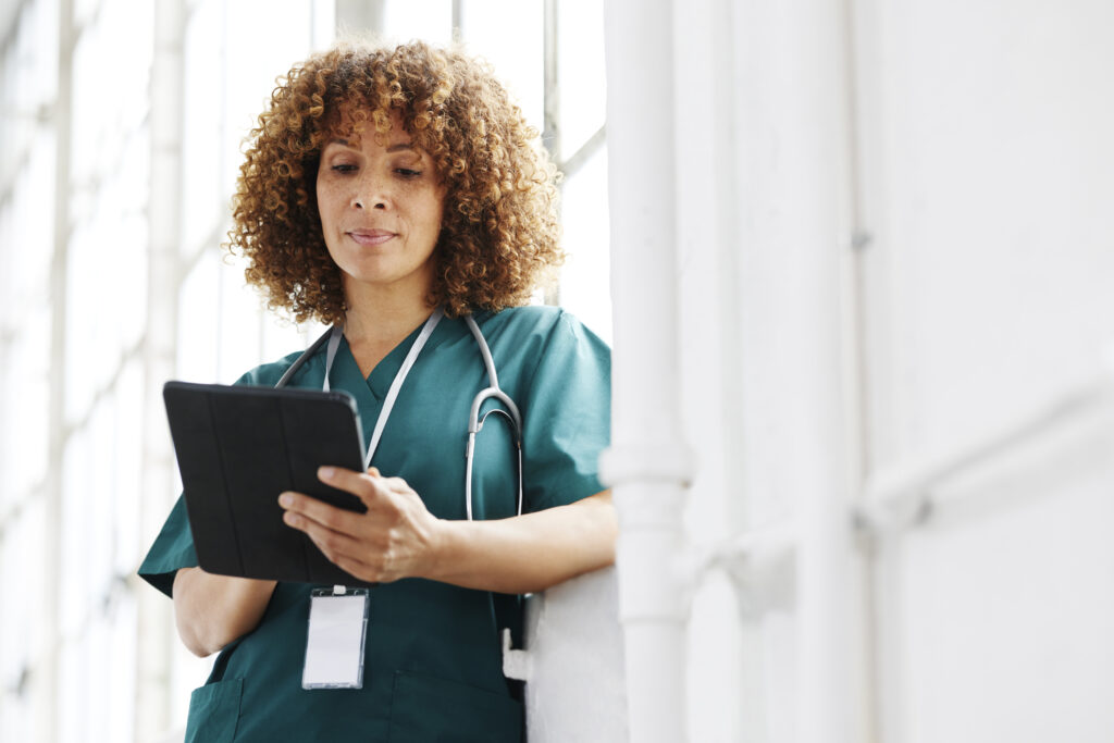 Woman in green scrubs looking at iPad