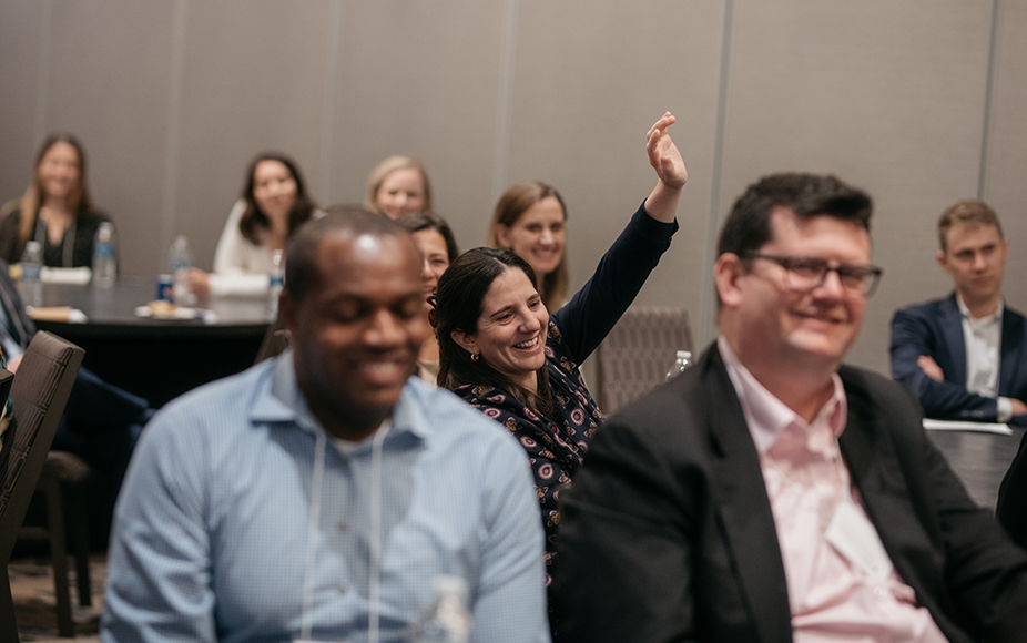 A CCS executive raises her hand at a meeting.