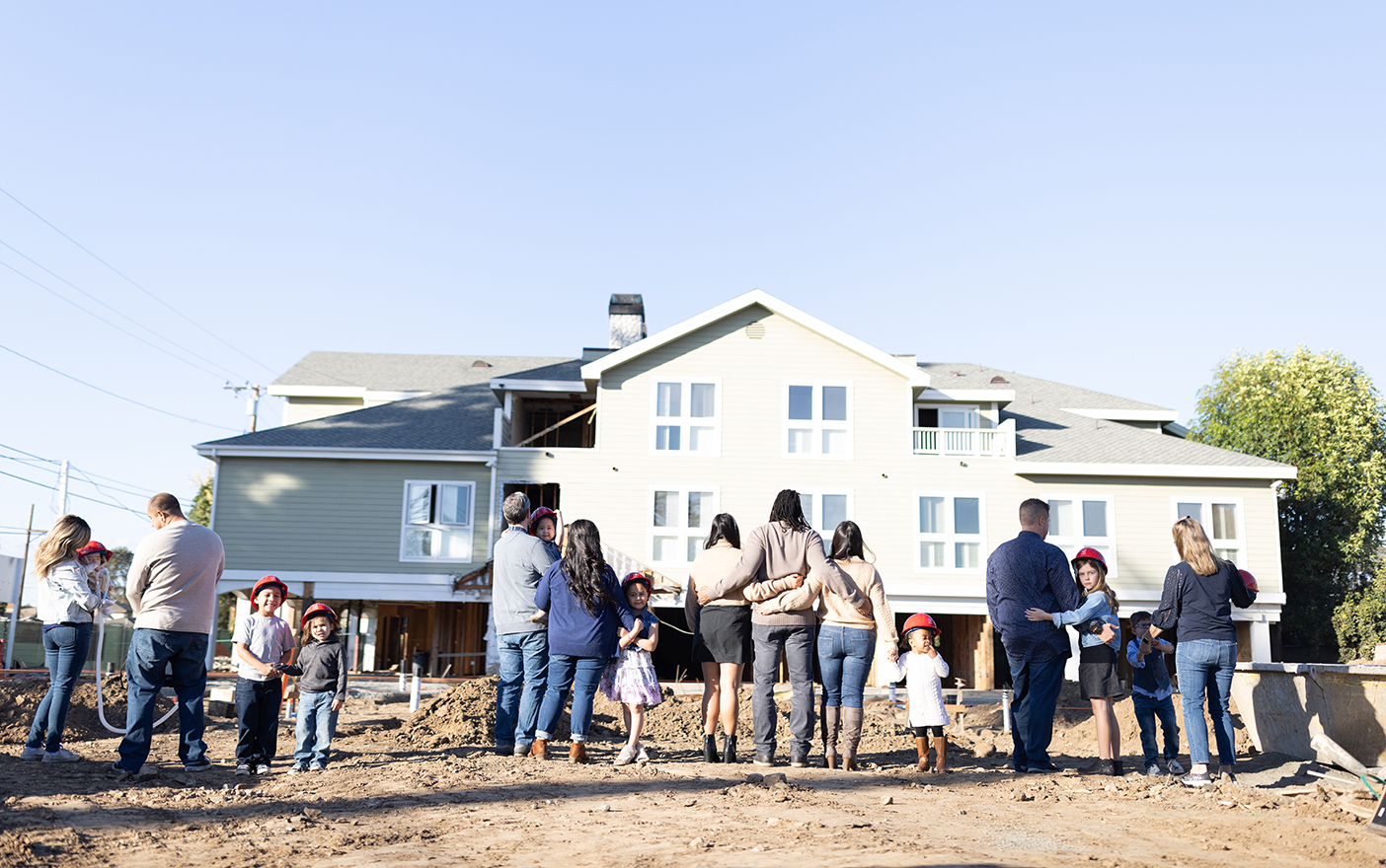 A picture of families standing in front of a house in construction as part of Ronald McDonald House Orange County.