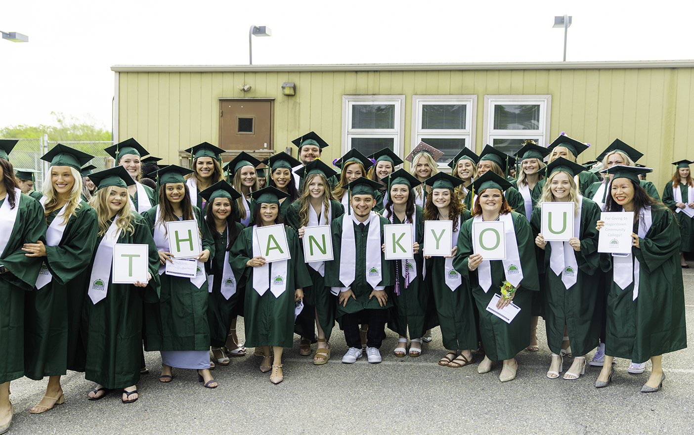 Hagerstown Community College graduates holding signs that spell 