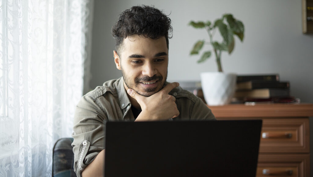 A picture of a fundraising professional sitting at their desk watching a webinar about AI on their laptop.