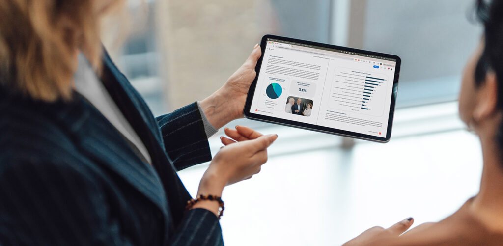 A picture of two fundraisers looking over insights from the 2025 Philanthropic Landscape on a tablet.